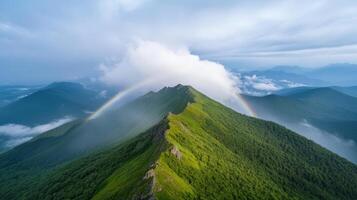 Majestic mountains with lush greenery and vibrant rainbow arching through clouds create serene photo