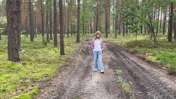 Young girl walking on a path in a pine forest video
