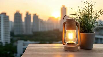 A lamp and a plant on a table with cityscape in the background photo