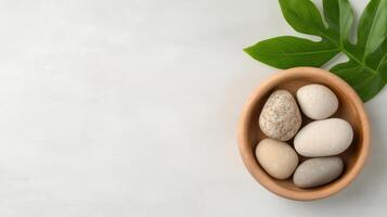 Stone pebbles and green leaf on white background photo