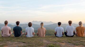 Five people sitting on a hill overlooking the mountains photo