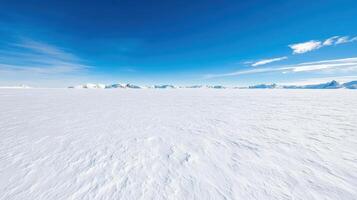 A large snow covered plain with mountains in the background photo