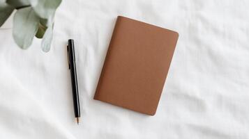 A5 notebook with pen and plant photo