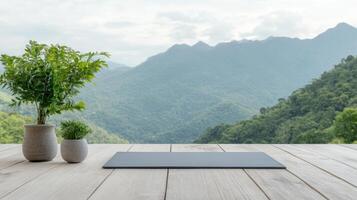 A yoga mat on a wooden table with mountains in the background photo