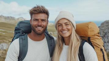 A couple with backpacks standing on a mountain photo