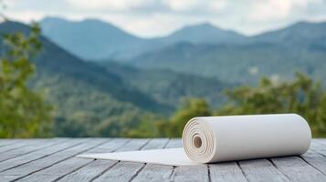 Roll of toilet paper on wooden table with mountains in background photo