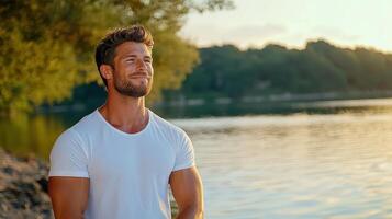 A man standing by a lake at sunset photo