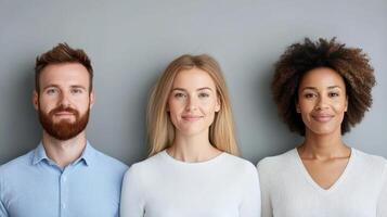 Three people standing in front of a gray wall photo
