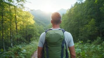Man with backpack walking through forest photo