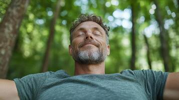 A man with his eyes closed in the woods photo