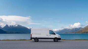 A white van parked in front of a lake and mountains photo