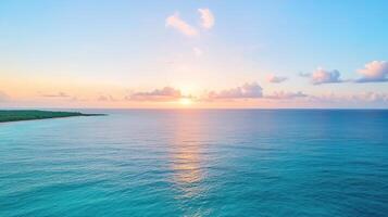 The sun sets over the ocean and the beach photo