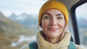 A woman wearing a yellow hat and scarf is smiling photo