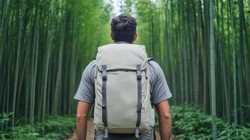 Man with backpack walking through bamboo forest photo