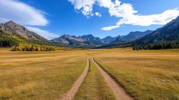 un suciedad la carretera Guías a un montaña rango en el otoño foto