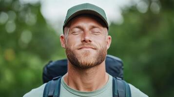A man with a backpack and hat is smiling photo