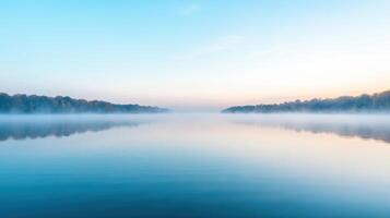 A lake with trees and fog in the background photo