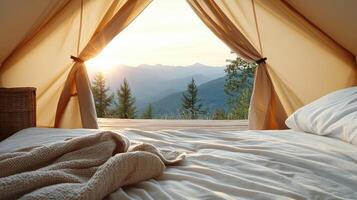 A bed with a blanket and pillows in front of a tent photo