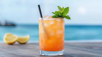 A drink with a straw and mint leaves on a table photo