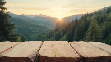 Wooden table top over mountain view with sun setting photo