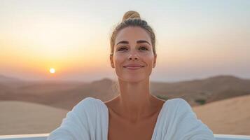 A woman smiles while sitting in a car at sunset photo
