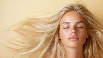 A beautiful blonde woman with her eyes closed and hair blowing in the wind photo