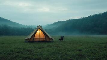 A tent in the middle of a field with a chair photo