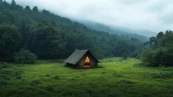 A tent sits in the middle of a green field photo