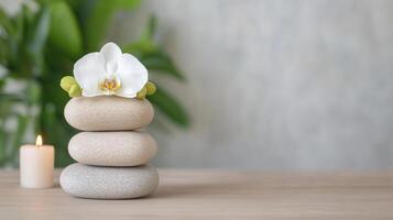 Stone stack with orchid and candle on wooden table photo