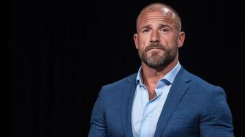 A bald man in a blue suit and white shirt photo