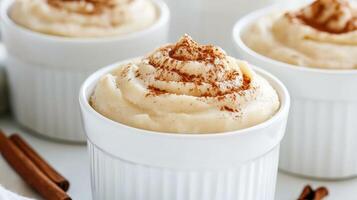 Cinnamon sugar pumpkin pudding in white cups photo