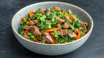 A bowl of meat and vegetables with sesame seeds photo