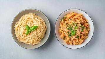 Two bowls of spaghetti and meatballs on a gray background photo