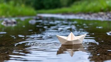 Paper boat floating in water photo