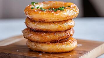 A stack of fried donuts on a wooden cutting board photo