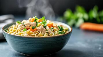 A bowl of pasta with carrots and chicken photo