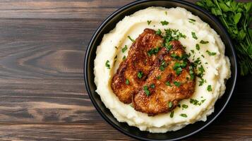 Chicken breast with mashed potatoes and parsley on a wooden table photo