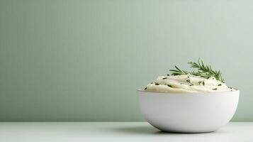 Mashed potatoes in white bowl on green background photo