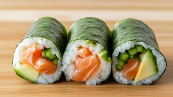 Three sushi rolls with salmon, avocado and cucumber photo
