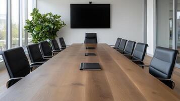 A conference table with black chairs and a large flat screen tv photo
