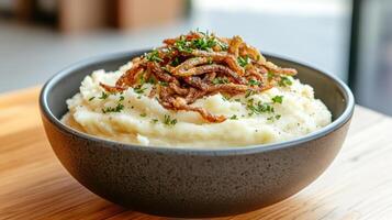 A bowl of mashed potatoes with onions and herbs photo