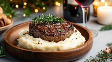 A steak is served on top of mashed potatoes with herbs photo