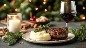 A plate with mashed potatoes, a steak and a glass of red wine photo