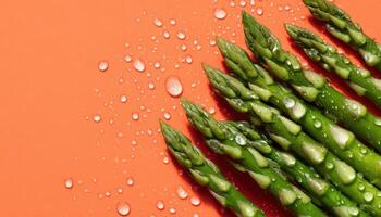 Dewy asparagus spears closeup vibrant orange background food photography fresh produce gourmet concept photo
