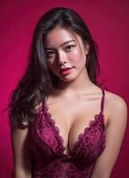 Elegant asian model posing in lingerie against a pink background fashion photography studio setting photo