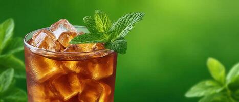 Refreshing iced tea drink with mint and ice cubes in a green natural setting photo