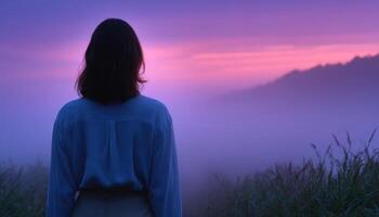 Lone woman silhouette in ethereal fog at sunrise nature landscape serene environment reflective viewpoint photo