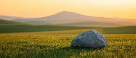 A solitary boulder overlooking grassy fields at dusk nature photography tranquil landscape photo