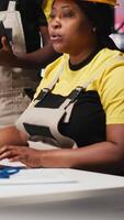 Vertical Black employees analyzing production line solar panels in the photovoltaics factory, analyzing data. Manufacturing plant engineers reading documentation files to troubleshoot errors. Camera A. video