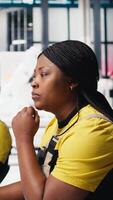 Vertical African American worker programs automation settings in solar facility, focused on efficiency and sustainability. Female engineer manages configurations for improved power output. Camera B. video